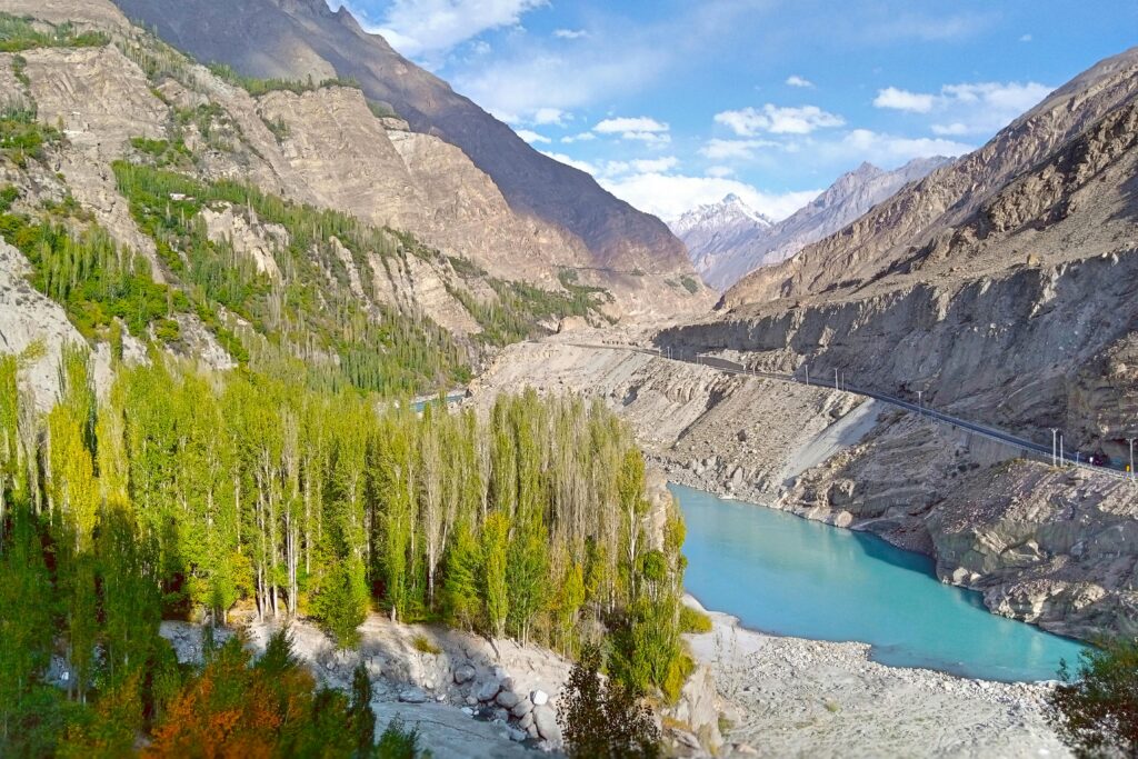 Beautiful landscape of a turquoise river winding through a lush green valley surrounded by mountains.