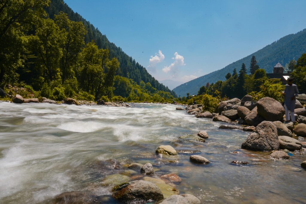 Experience the tranquil beauty of Kangan's river valley, surrounded by lush forests and rolling hills.